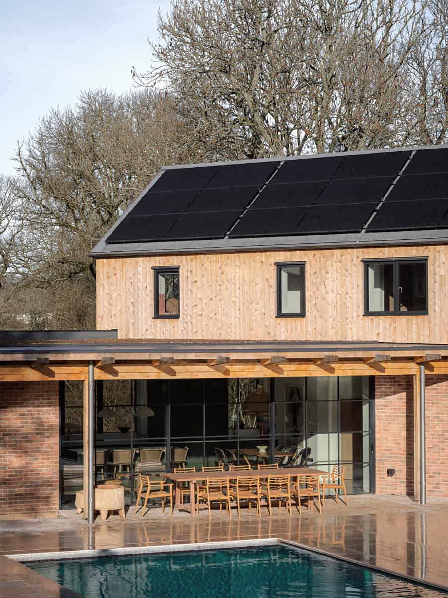 Hazelbridge Cottage rear elevation with timber gable, floor-to-ceiling glass, and living room beyond